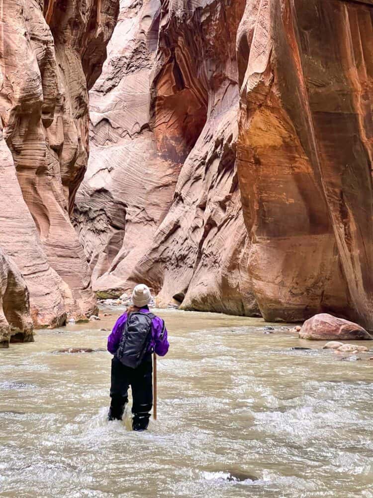 Erin on The Narrows river hike in Zion National Park with the Matador Beast 18 backpack. 