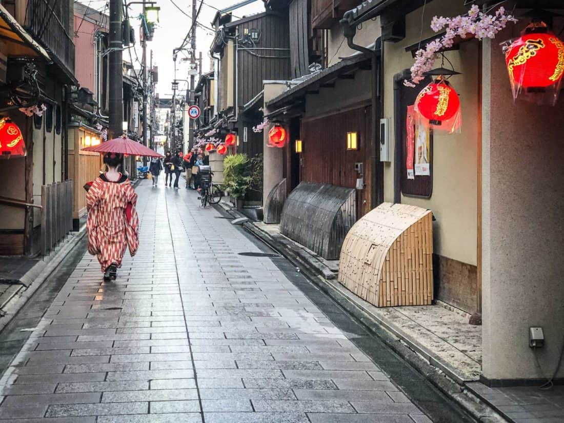 A maiko (apprentice geisha) in the rain on a street in Miyagawacho near Gion, Kyoto