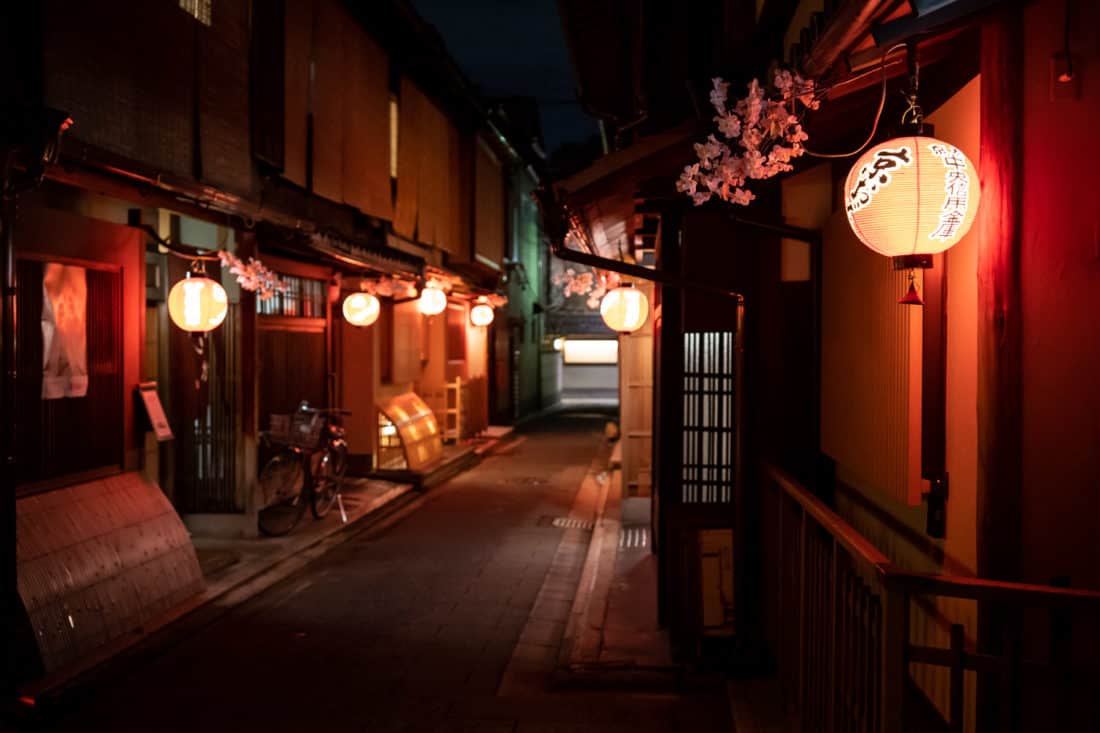 The narrow streets of Miyagawacho near Gion lit up with lanterns at night in Kyoto, Japan