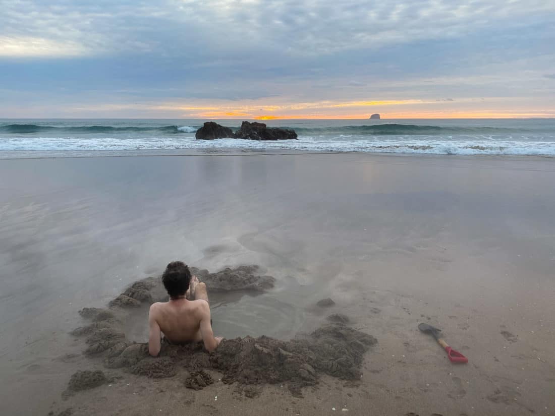 Digging your own spa bath at Hot Water Beach at sunrise on New Zealand's North Island