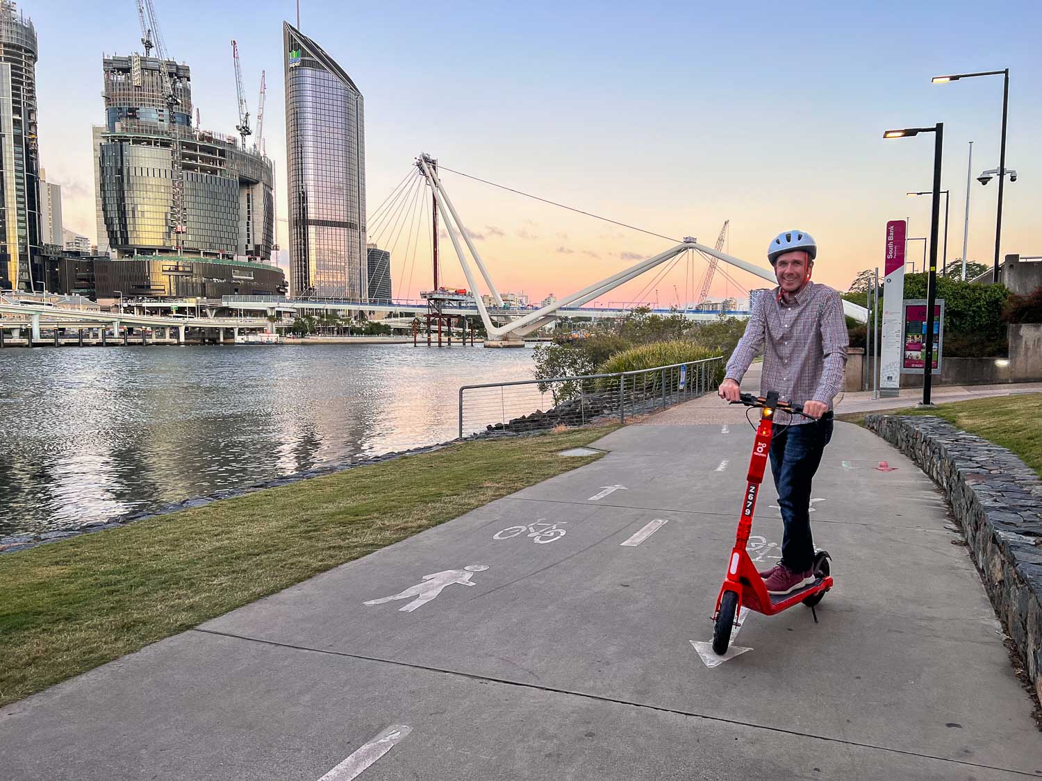 Simon on a scooter along the riverside walkway, Brisbane, Australia