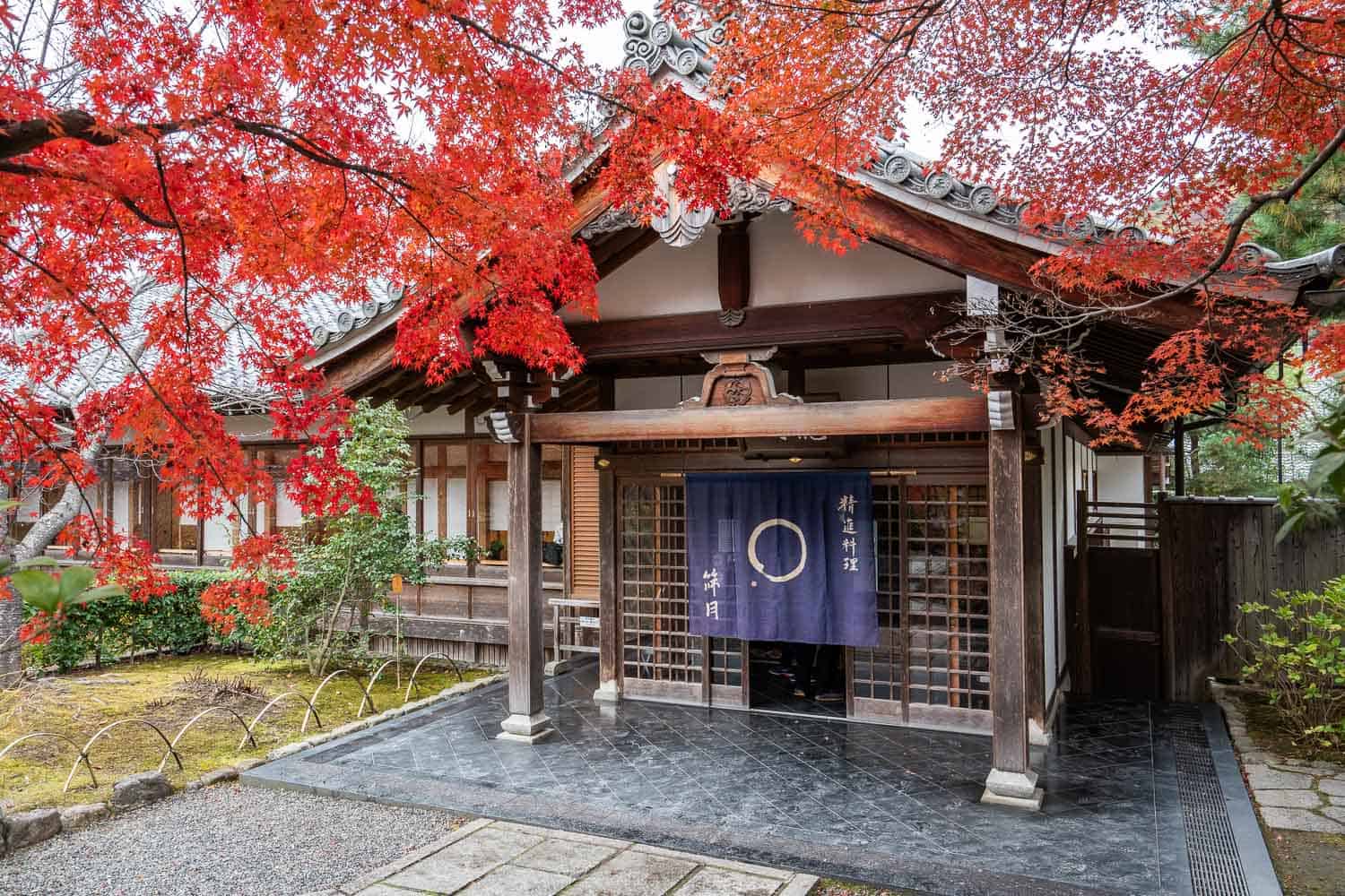 Entrance to Shigetsu vegetarian restaurant in Tenryuji temple in Arashiyama Kyoto framed by autumn leaves. 