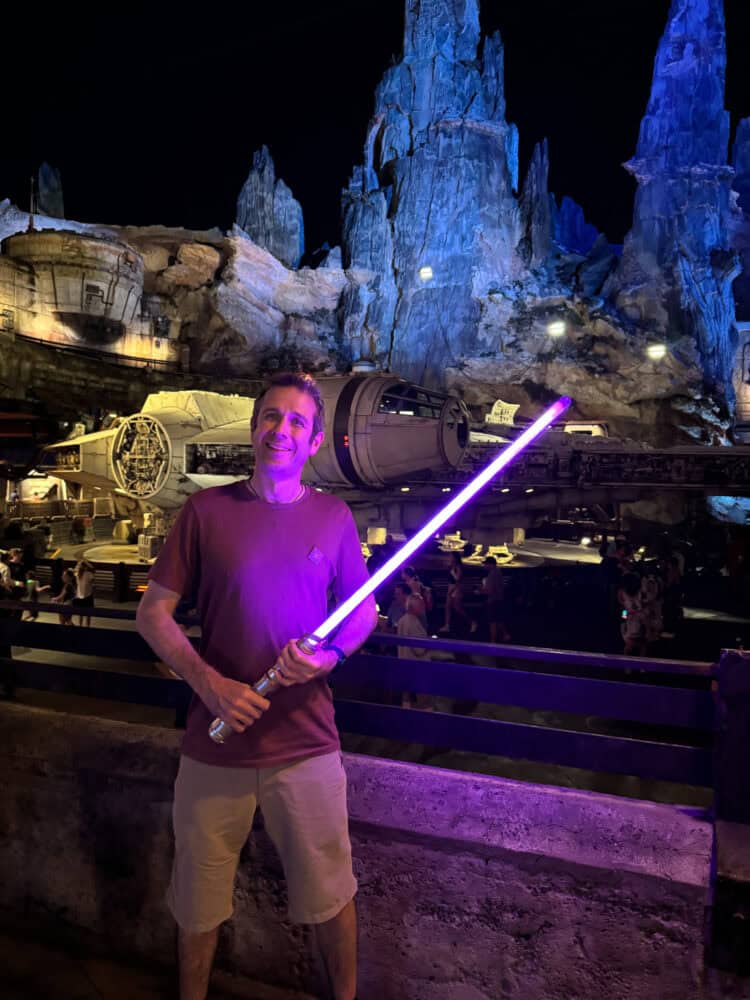 Simon with purple lightsaber at night at Millennium Falcon in Galaxy's Edge at Hollywood Studios