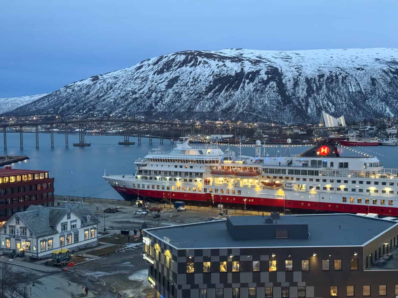 View of Tromso harbour, bridge and Arctic Cathedral at dusk from the Clarion Hotel The Edge.